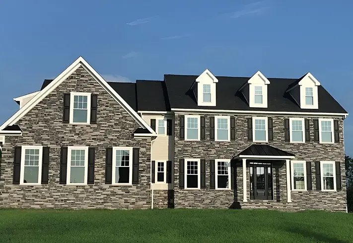 Large brick house with green lawn.