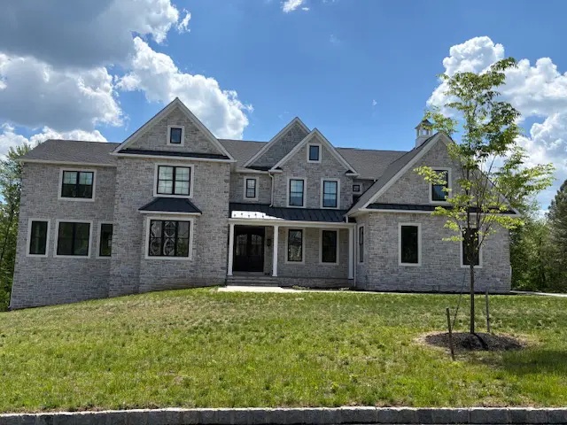 A large brick house with a tree in front of it.